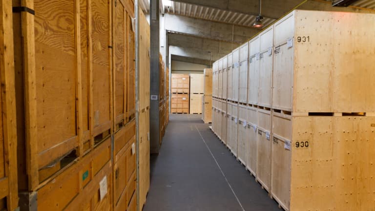 Alarm-protected warehouse with numbered wooden crates for the secure commercial storage of company inventory.