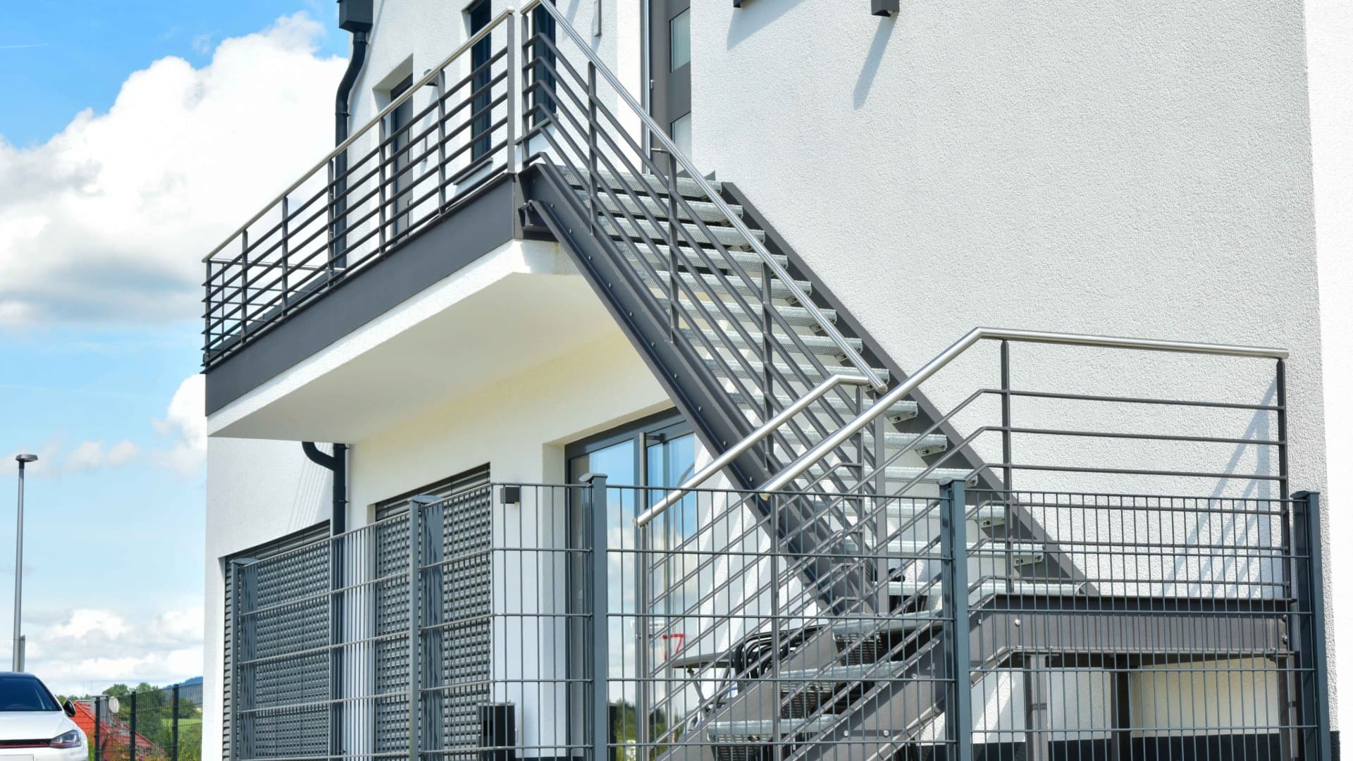 External staircase with railing at a building – long carrying distance via multiple steps to the entrance.