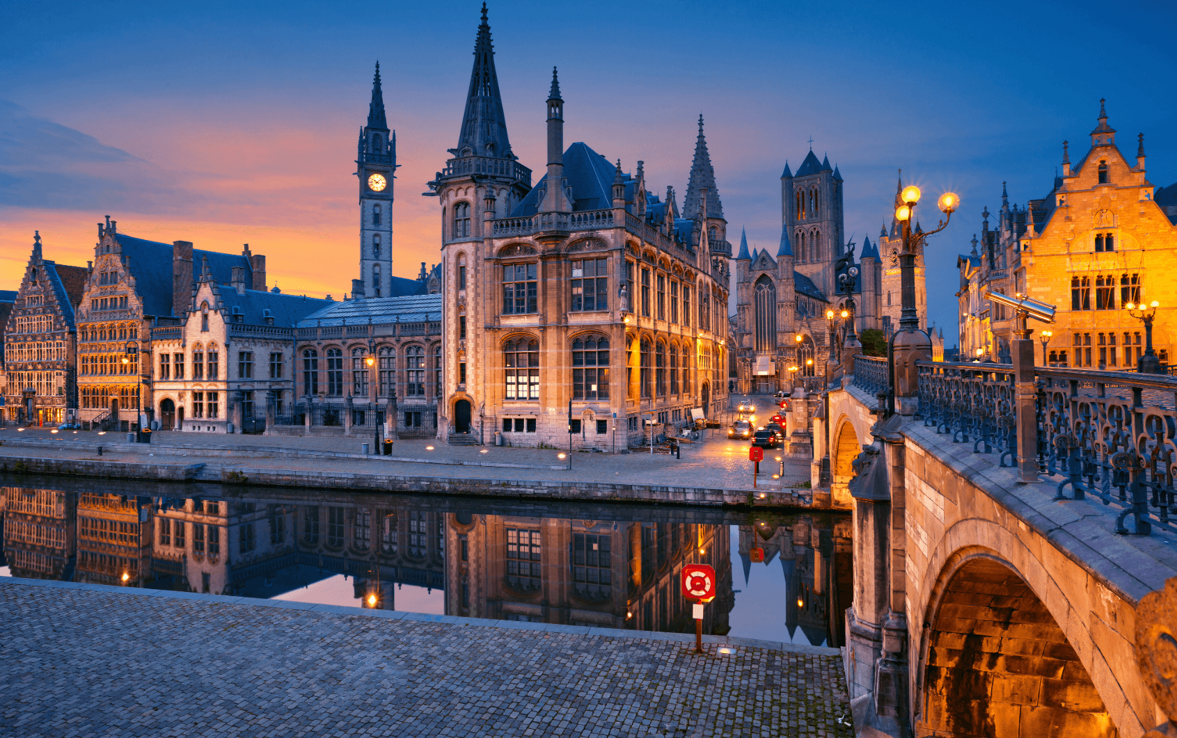 Historische Altstadt von Gent mit Kanal und beleuchteten Gebäuden am Abend