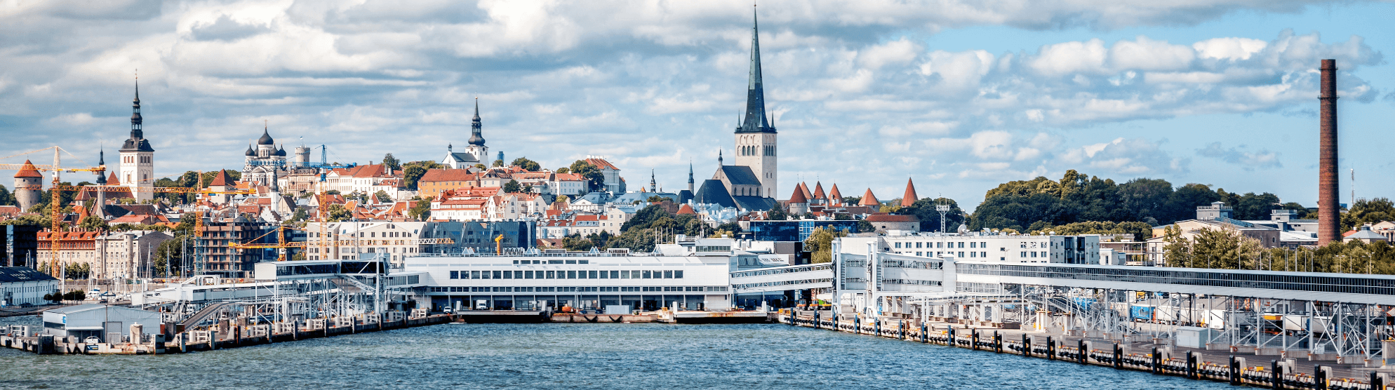 Stadtansicht von Tallinn mit Hafen, Altstadt und Kirchtürmen unter bewölktem Himmel