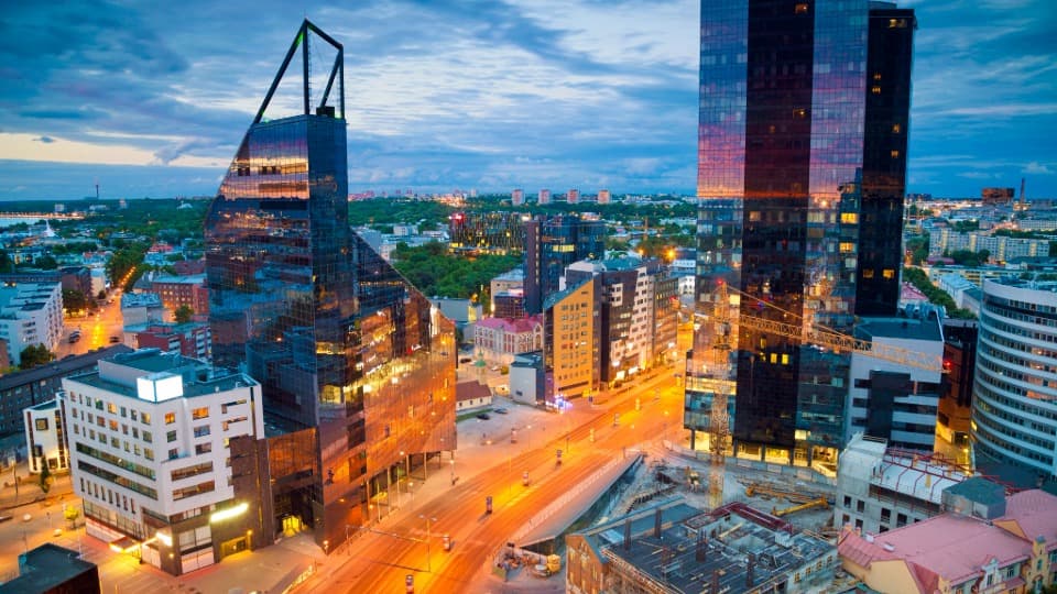 Moderne Hochhäuser und beleuchtete Straße im Stadtzentrum von Tallinn bei Abenddämmerung