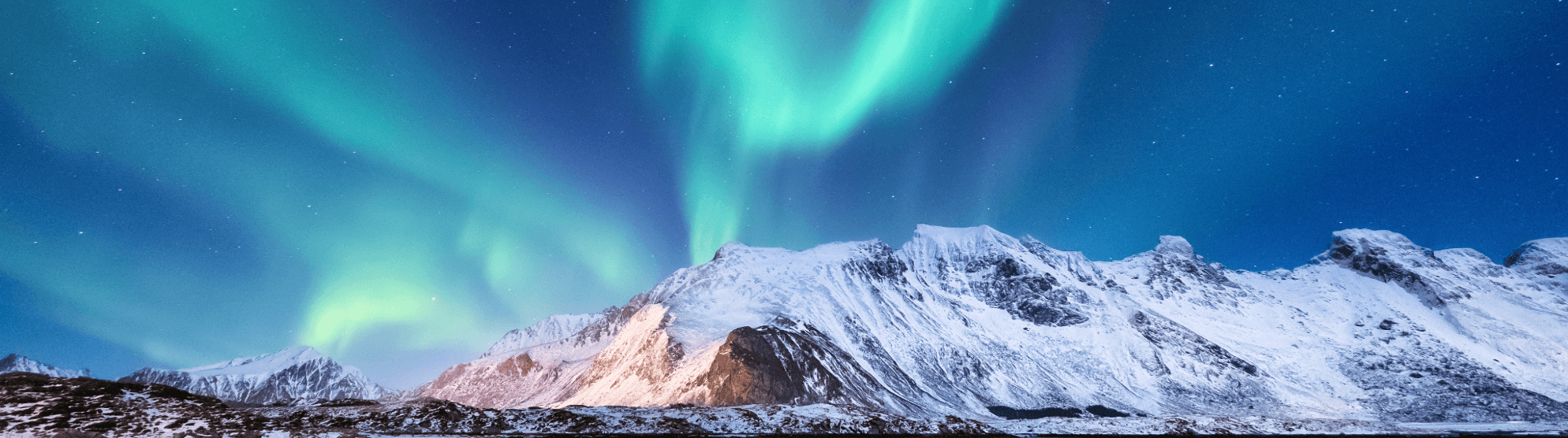 Nordlichter über schneebedeckten Bergen in Finnland bei klarem Nachthimmel