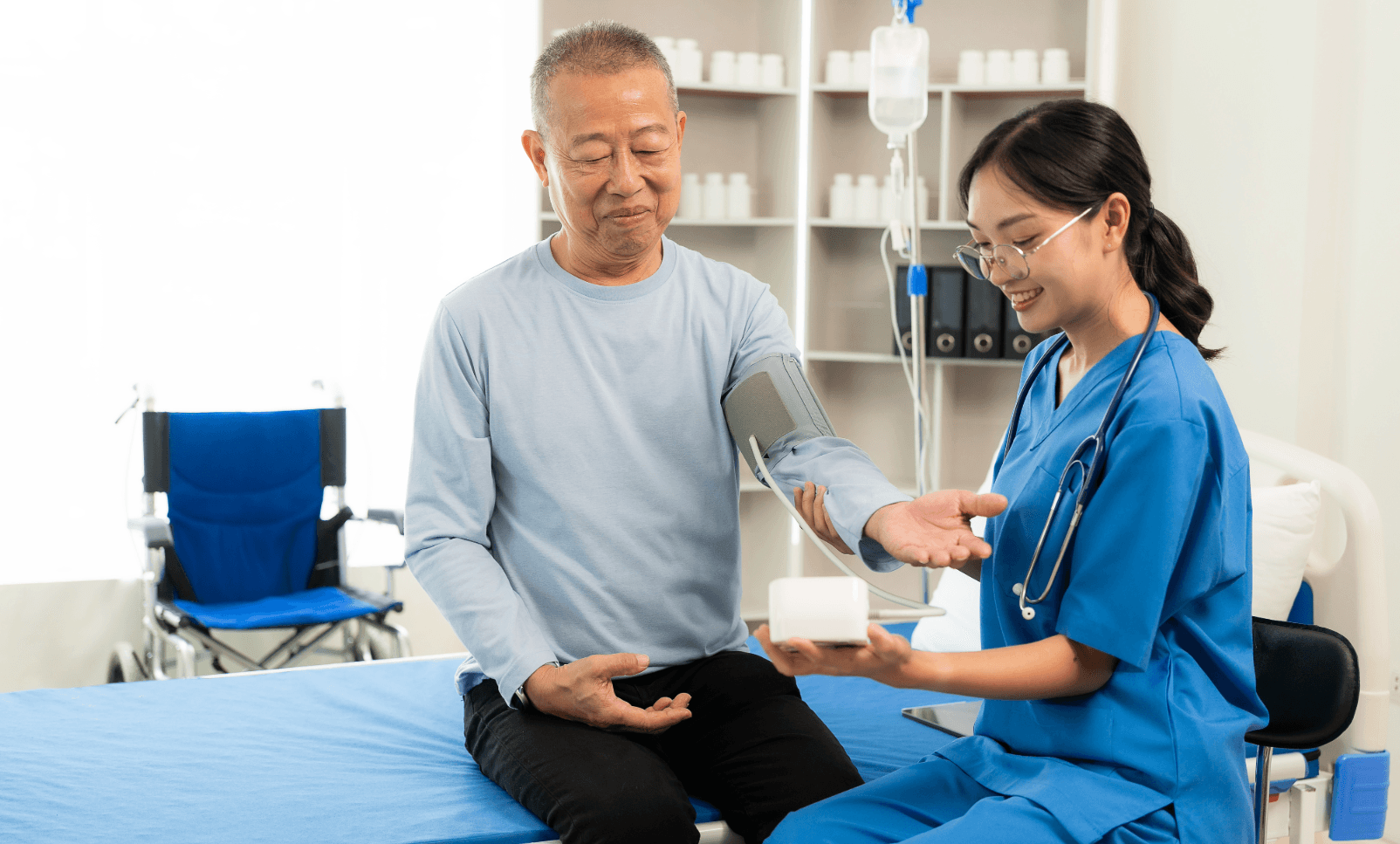 Older patient having blood pressure checked in a South Korean clinic with a nurse