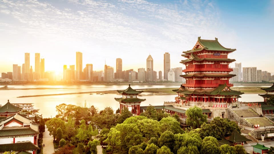 Luftbild einer historischen Stadt in China, im Hintergrund sieht man eine große, moderne Metropole