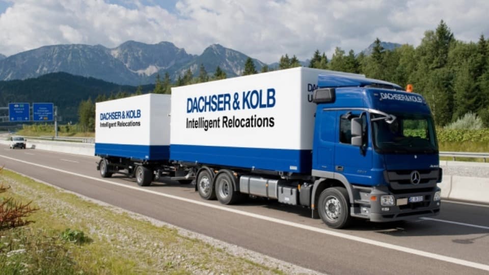 A blue DACHSER & KOLB moving truck with trailer on the highway, ensuring transport capacity within the nationwide network.