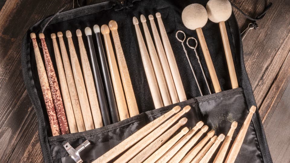 Eine geöffnete Tasche mit verschiedenen Drumsticks, Mallets und einem Stimmschlüssel liegt bereit für den Umzug mit DACHSER & KOLB.