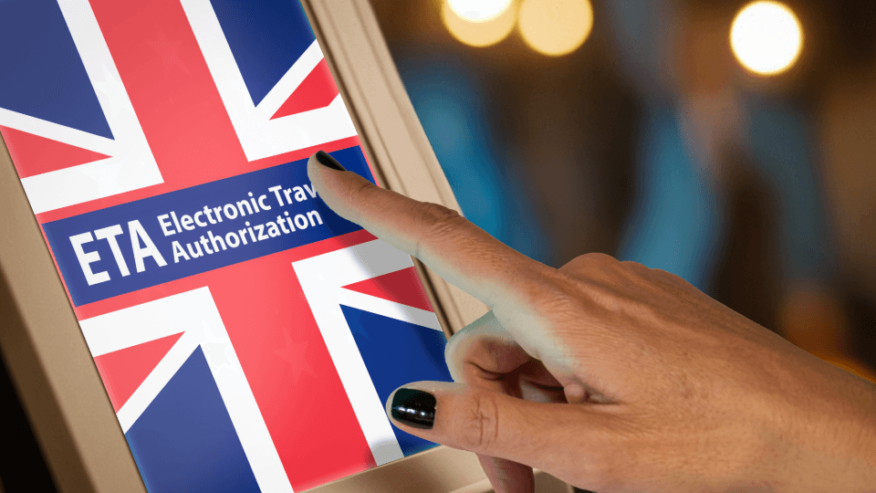 Hand touching screen with UK flag and ETA Electronic Travel Authorization for UK entry approval
