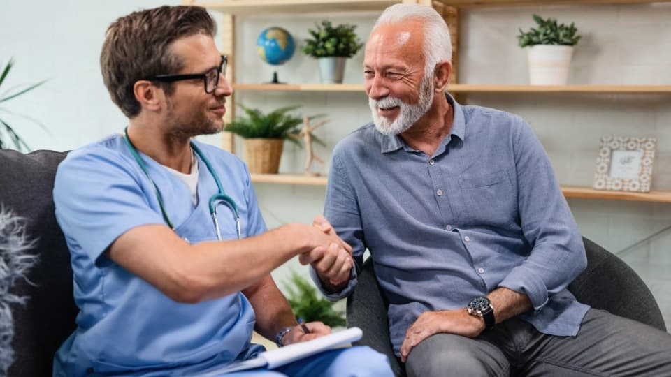 Ein Hausarzt begrüßt einen Patienten per Handschlag – Symbol für die persönliche medizinische Versorgung in Italien.