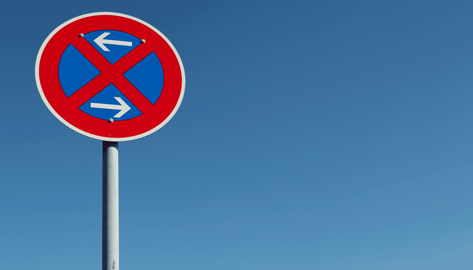 No-stopping sign against blue sky – temporary no-parking zone for a move to keep loading access clear.