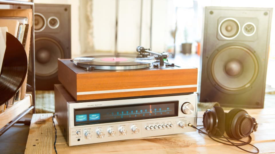 Eine vollständige HiFi-Anlage mit Vintage-Receiver, Holz-Plattenspieler und großen Lautsprechern vor dem sicheren Transport durch DACHSER & KOLB.