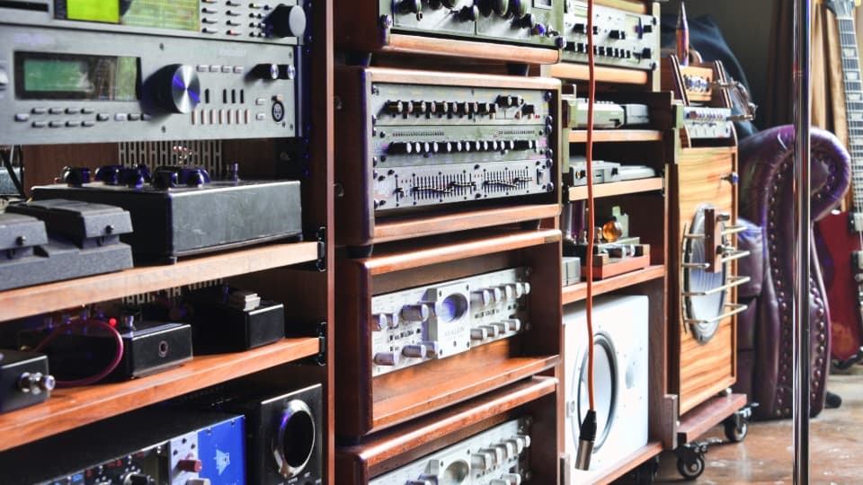 Mehrere mit hochwertigen Audiogeräten bestückte HiFi-Racks aus Holz vor dem sicheren Möbeltransport durch DACHSER & KOLB.