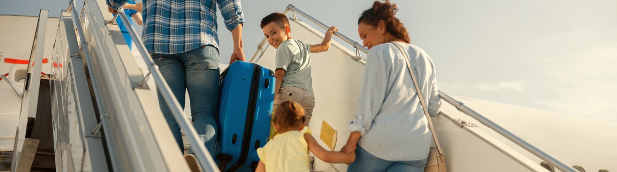 Family with children boarding an airplane – symbolic image for international moving