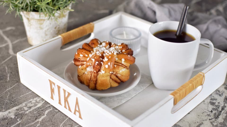 Kaffee und schwedische Zimtschnecke als Symbol der Fika‑Kultur in Schweden