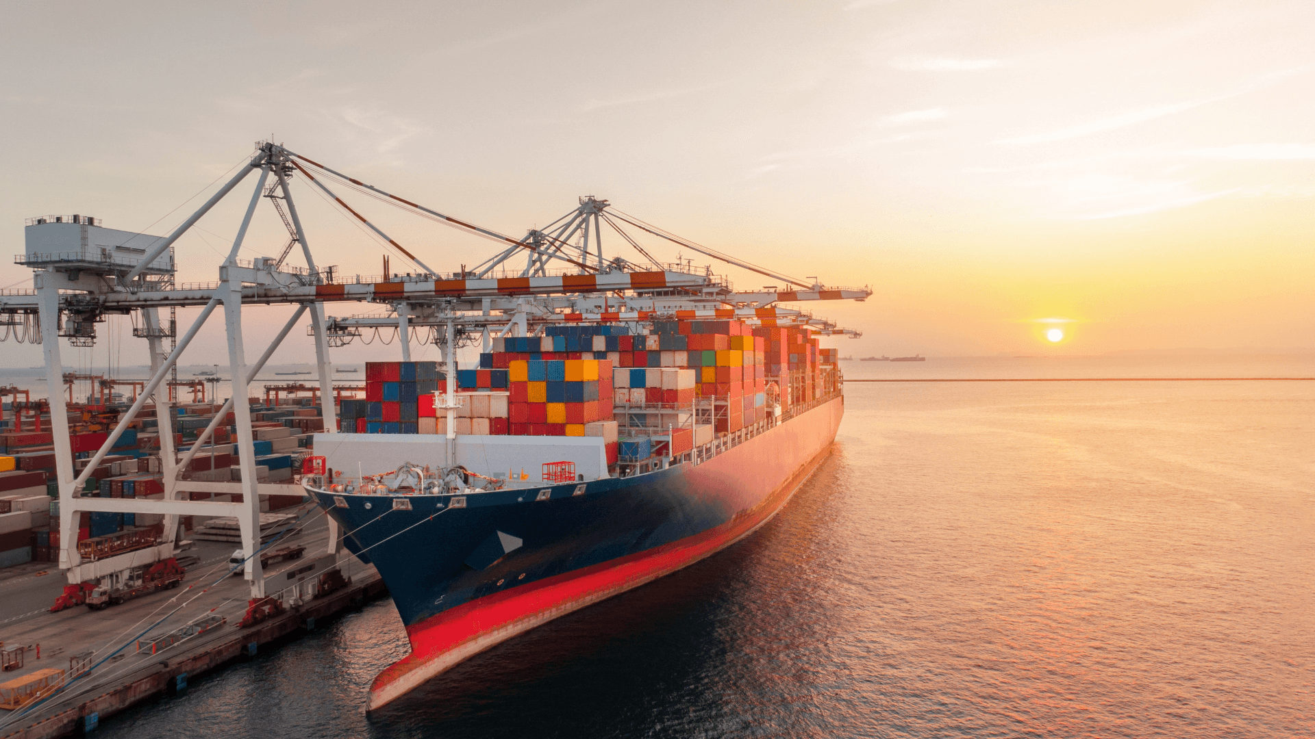 Containerschiff im Entladehafen bei Sonnenuntergang – Symbol für POD (Port of Discharge) im Seehandel.