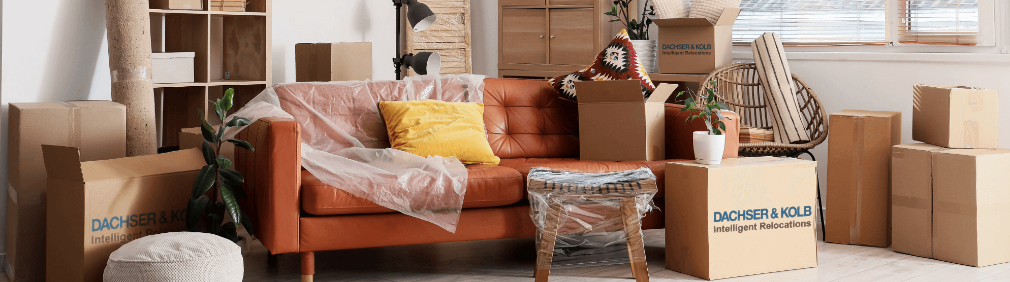 Wohnzimmer mit verpackten Möbeln und Kartons – Symbolbild für professionelle Neumöbellogistik