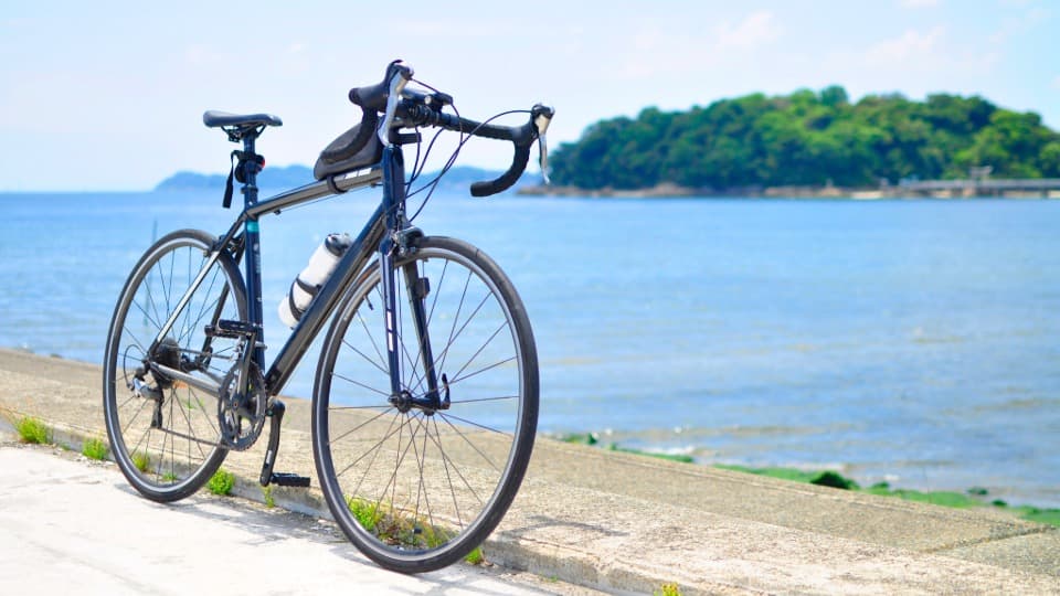 Ein hochwertiges Rennrad vor einem Gewässer, bereit für den sicheren Spezialtransport durch das Umzugsunternehmen DACHSER & KOLB.