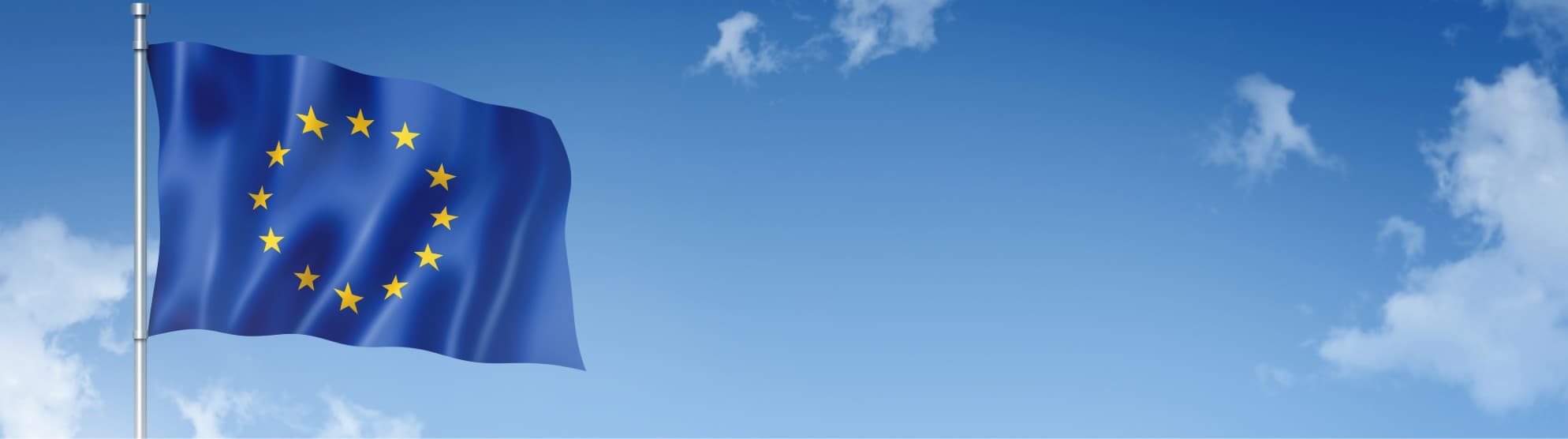 Wehende EU-Flagge vor blauem Himmel als Symbol für den zollfreien Status von Unionswaren beim T2LF-Verfahren.
