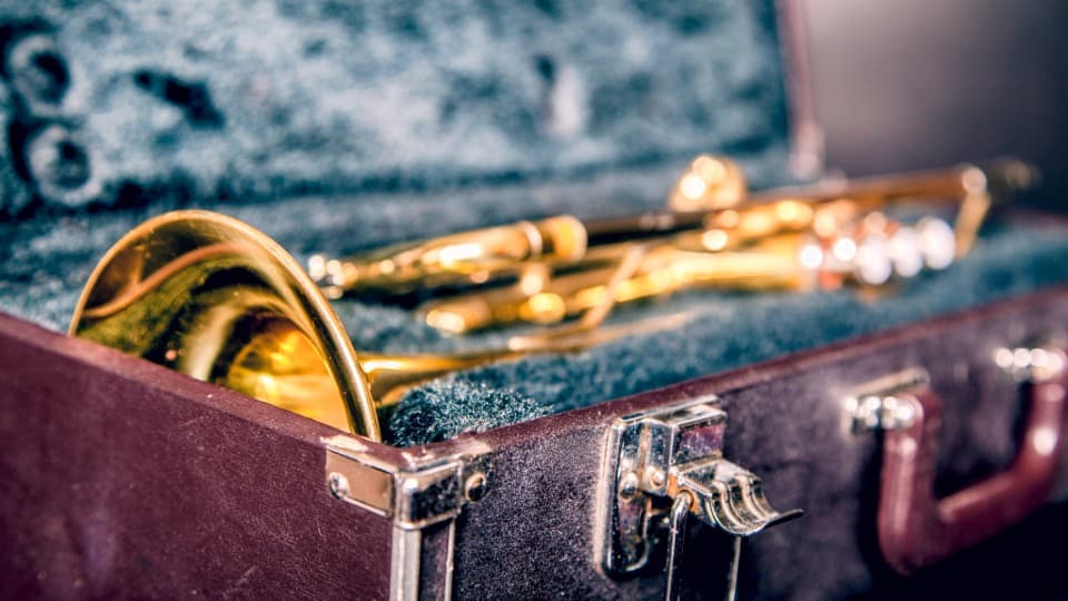 Eine goldene Trompete liegt sicher verpackt in ihrem offenen Transportkoffer als Vorbereitung für den Umzug mit DACHSER & KOLB.