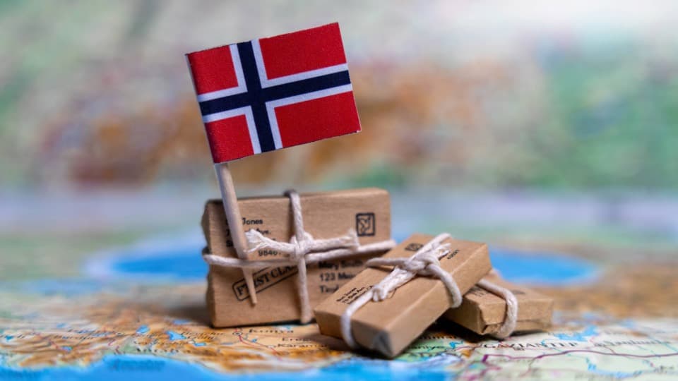 Norwegian flag on small parcels on a map, symbolic image for entry to Norway
