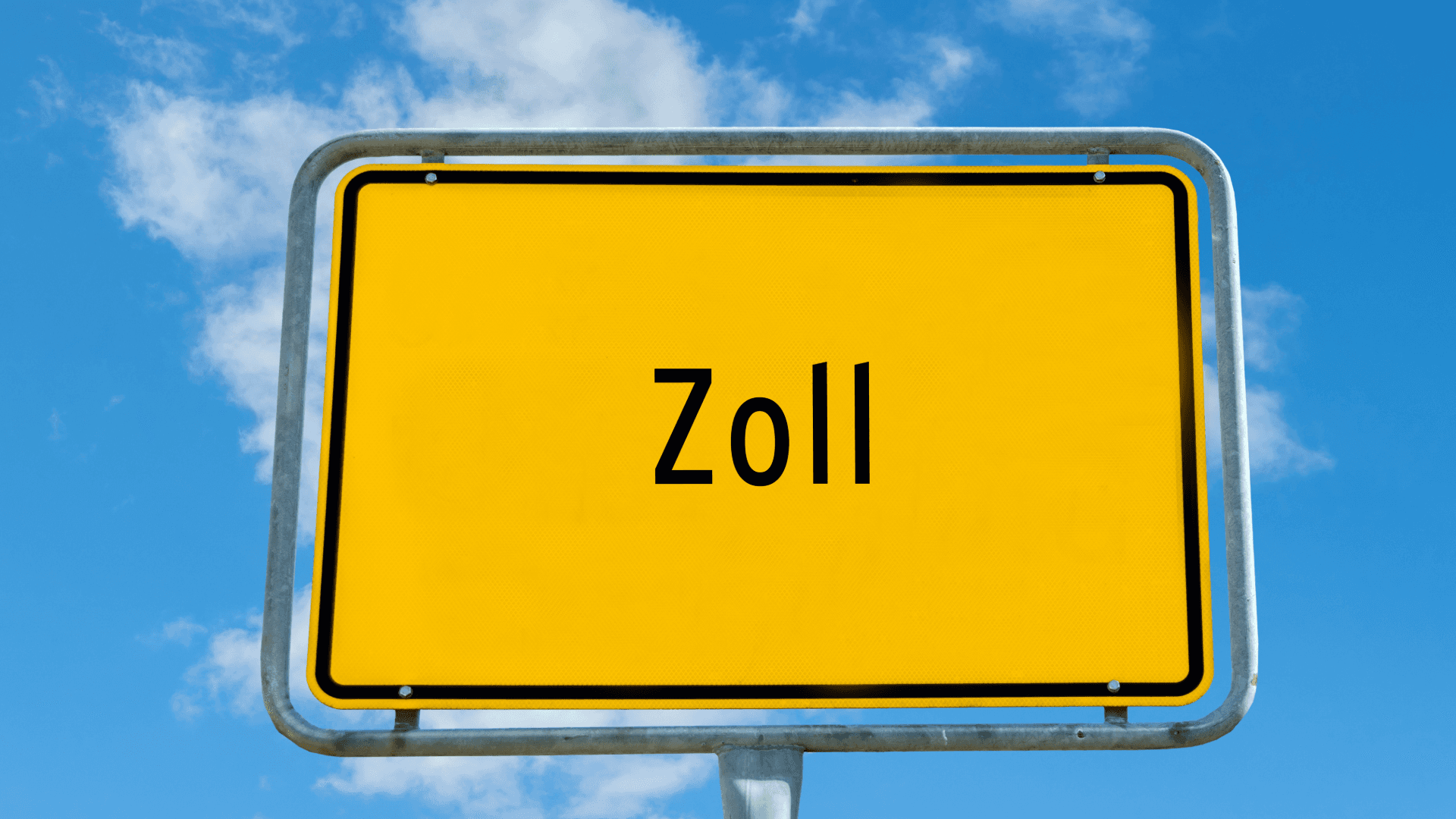 Yellow road sign reading “Zoll” against a blue sky