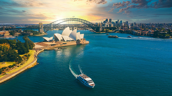 Luftaufnahme vom Sydney Opera House und der Harbour Bridge bei Sonnenuntergang für den Auslandsumzug nach Australien mit DACHSER & KOLB.