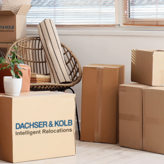 Wohnzimmer mit verpackten Möbeln und Kartons – Symbolbild für professionelle Neumöbellogistik