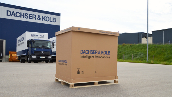 Große Umzugskiste vor DACHSER & KOLB Lager – Kleintransporte für Möbel professionell organisiert.