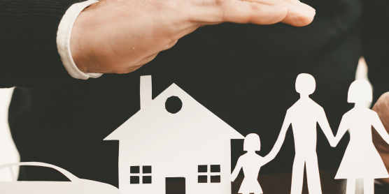 Schützende Hände über Haus, Auto und Familie – Symbolbild für Versicherungsoptionen beim Umzug.