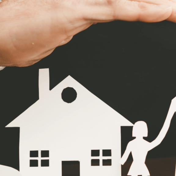Schützende Hände über Haus, Auto und Familie – Symbolbild für Versicherungsoptionen beim Umzug.