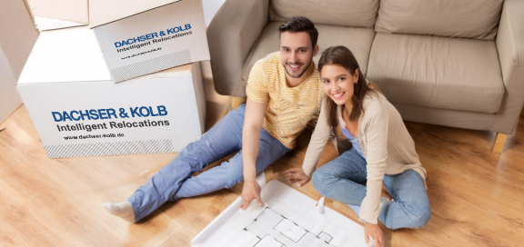 Junges Paar plant mit Umzugsplan und Kartons – Spartipps beim Umzug dank frühzeitiger Organisation und Planung