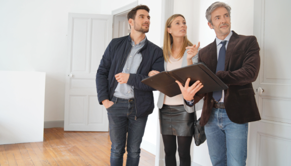 Paar bei Wohnungsbesichtigung mit Makler – Spartipps beim Umzug durch kostenlose Vor-Ort-Termine nutzen