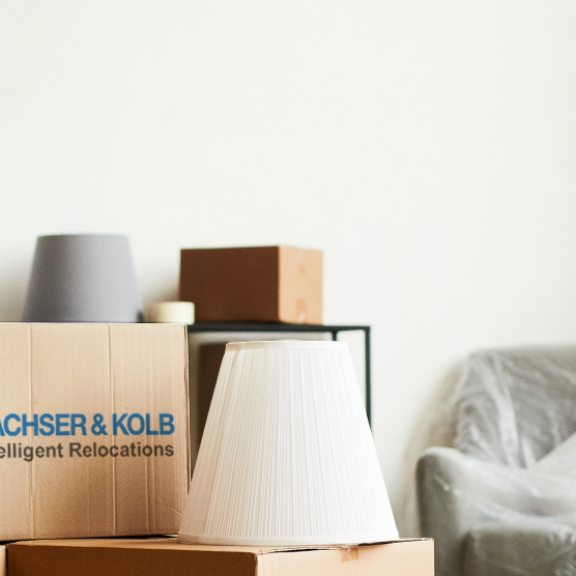 Umzugskartons in leerer Wohnung als Symbol für bevorstehende Wohnungsauflösung nach Kündigung der Wohnung