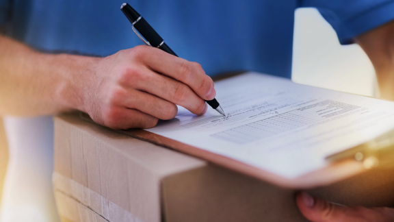 Empfänger unterschreibt auf Paketdokument – Proof of Delivery (POD) als Nachweis für die ordnungsgemäße Zustellung
