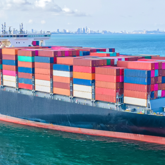 Containerschiff auf See mit bunten Containern, präzise Planung der Estimated Time of Departure (ETD) für reibungslose Logistik.