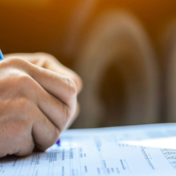 Eine Zollbeamtin und ein Zollbeamter inspizieren Waren bei einer Zollbeschau. Wichtig für die Einhaltung von Vorschriften.