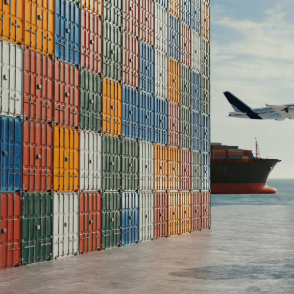 Ein LKW mit Container vor einem Stapel weiterer Frachtcontainer und im Hintergrund ein Frachtschiff sowie ein Flugzeug, die globale Logistik und die Bedeutung des Volumengewichts illustrierend.