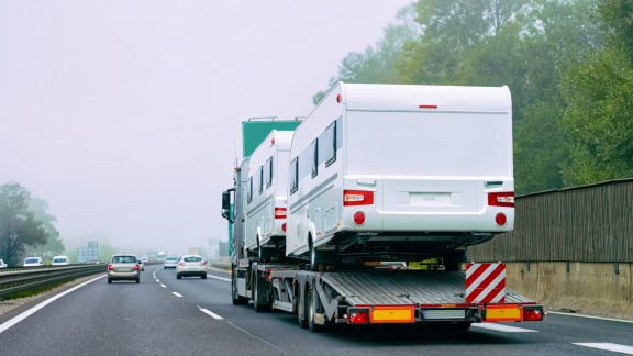 Lkw transportiert Wohnmobile auf Tieflader – sicherer Transport großer Fahrzeuge