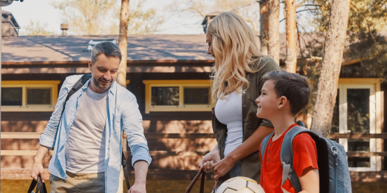 Familie packt Koffer in das Auto. Symbol für einen Umzug oder eine Reise mit Relocation Service für Privatpersonen.