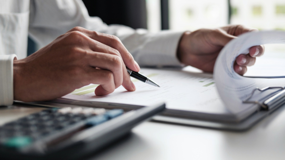 Hands review quote and cost calculation for edge protection (Kantenschutz) – documents, pen and calculator