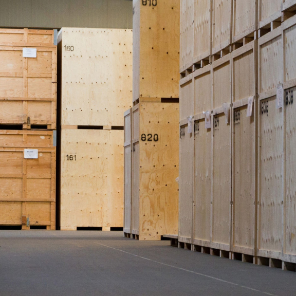 Row of numbered wooden crates in a secured moving warehouse for the safe storage of goods.
