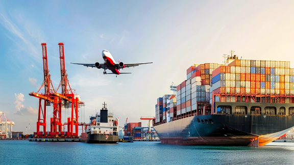 Ein großes Containerschiff liegt im Hafen neben roten Verladekranen, während ein Passagierflugzeug darüber aufsteigt als Symbol für die Kombination aus Seefracht und Luftfracht beim Umzug.