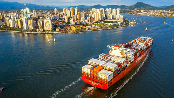 Ein voll beladenes Containerschiff der Hamburg Süd läuft im Hafen von Santos in Brasilien ein für den Container-Umzug nach Südamerika mit DACHSER & KOLB.